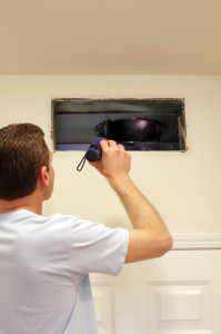 Man Looking into Air Duct